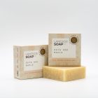 A picture of a Laneside Soap Company oats and maple soap bar sat slight in front of a packaged version of the product, with another packaged version of the product sat on top of it.
