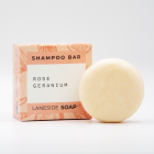 A picture of a Laneside Soap Company rose geranium shampoo bar sat slightly in front of it's packaging
